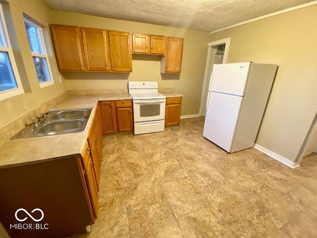 kitchen featuring a textured ceiling, white appliances, and sink