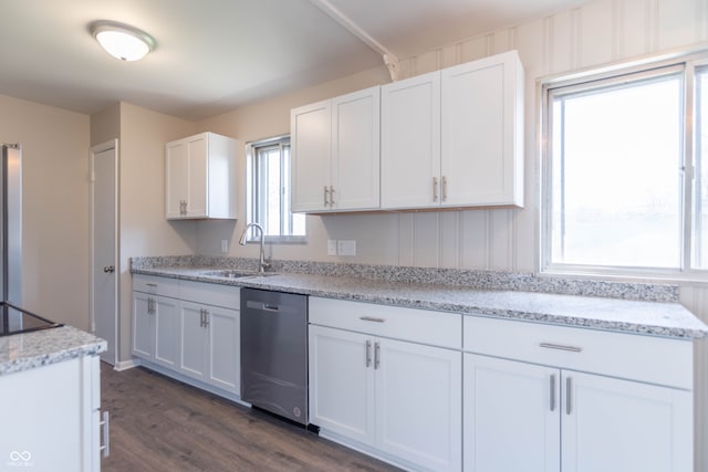 kitchen with light stone countertops, sink, white cabinets, and dishwasher