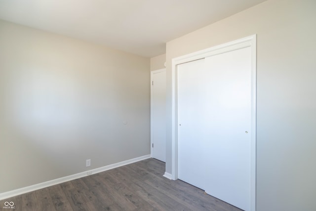 unfurnished bedroom featuring dark wood-type flooring and a closet