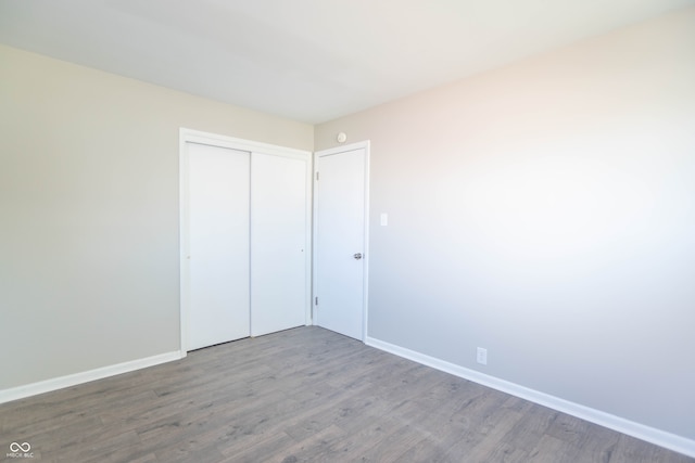 unfurnished bedroom featuring a closet and hardwood / wood-style floors