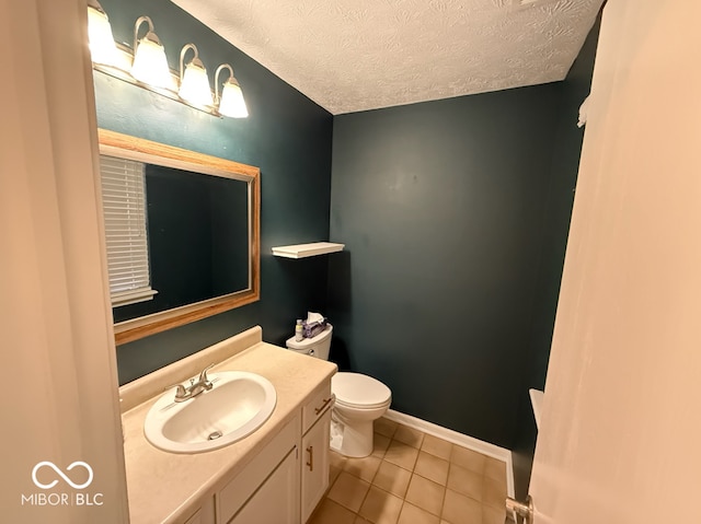 bathroom with tile patterned floors, vanity, a textured ceiling, and toilet