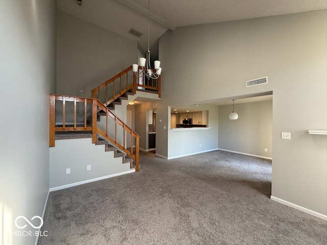 unfurnished living room with carpet floors, high vaulted ceiling, and a notable chandelier