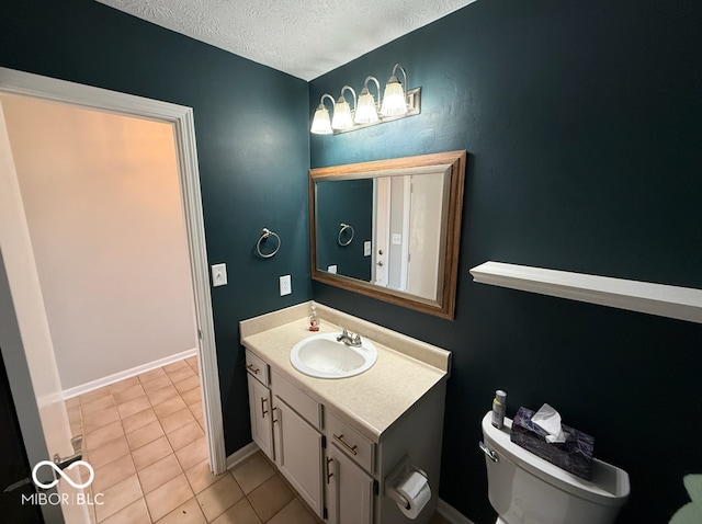 bathroom with tile patterned floors, vanity, a textured ceiling, and toilet