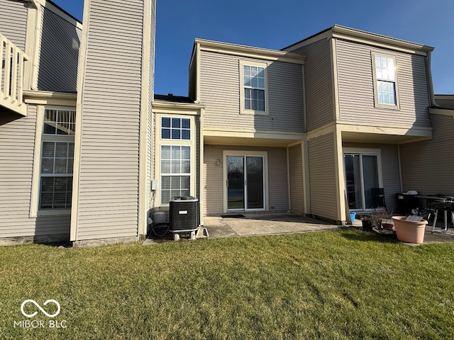 rear view of house with a yard, a patio, and central AC