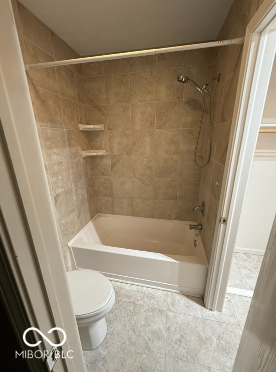 bathroom featuring tiled shower / bath combo and toilet