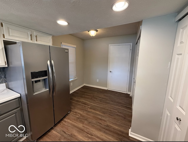 kitchen featuring stainless steel fridge with ice dispenser, white cabinetry, dark hardwood / wood-style flooring, and a textured ceiling