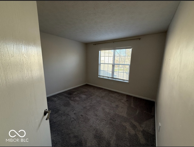 carpeted empty room with a textured ceiling