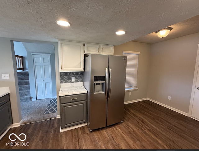 kitchen featuring white cabinets, stainless steel refrigerator with ice dispenser, dark hardwood / wood-style floors, a textured ceiling, and tasteful backsplash