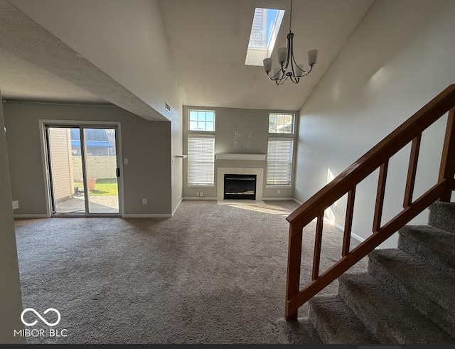 unfurnished living room with carpet, high vaulted ceiling, and a notable chandelier