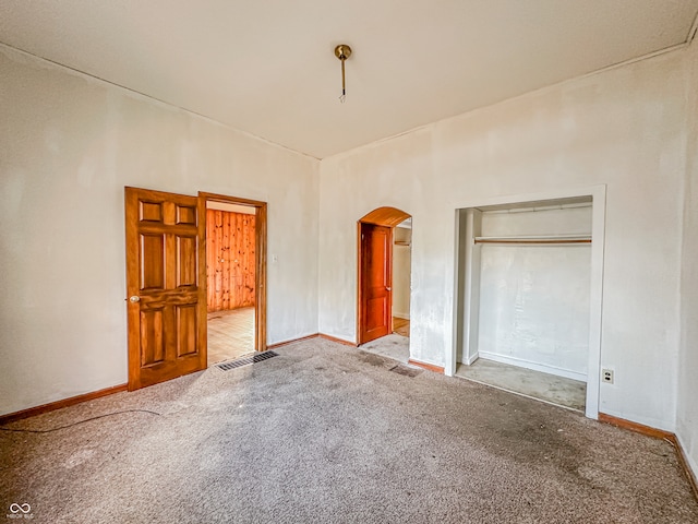 unfurnished bedroom with light carpet and a closet