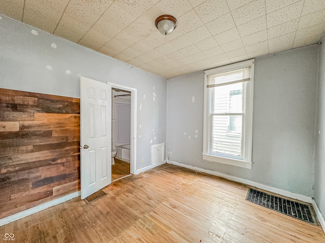 unfurnished room with hardwood / wood-style flooring