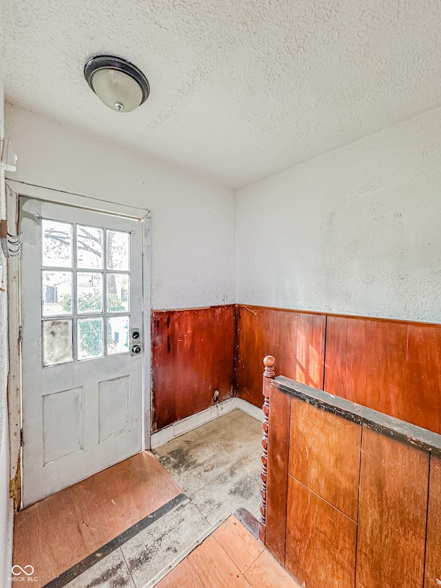 doorway to outside with a textured ceiling