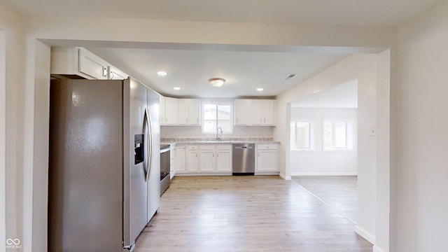 kitchen with white cabinetry, appliances with stainless steel finishes, sink, and light wood-type flooring