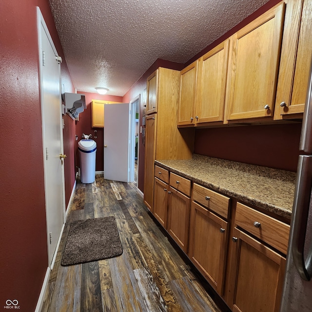 kitchen with dark hardwood / wood-style flooring and a textured ceiling