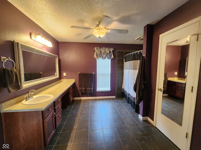 bathroom featuring tile patterned flooring, ceiling fan, a textured ceiling, curtained shower, and vanity