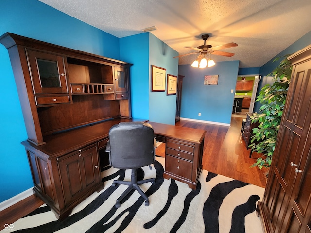 office featuring hardwood / wood-style flooring, ceiling fan, and a textured ceiling