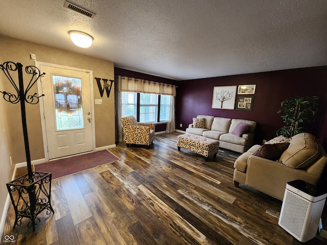 living room with dark hardwood / wood-style flooring and a textured ceiling