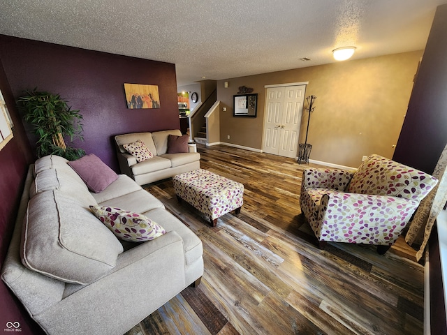 living room featuring wood-type flooring and a textured ceiling