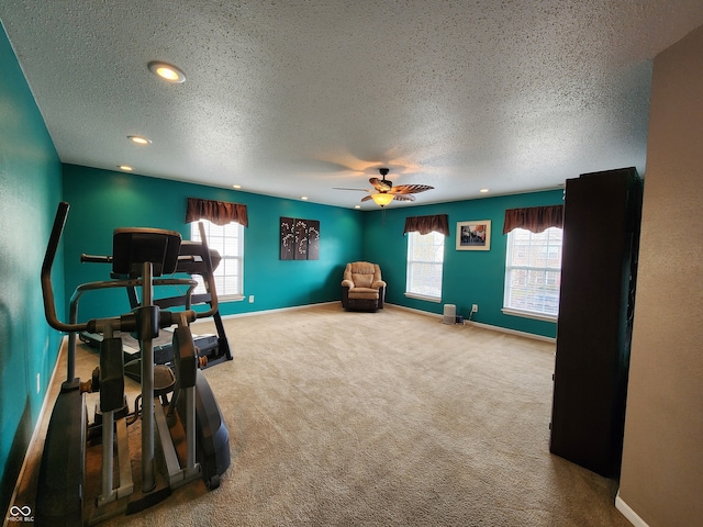 interior space with carpet flooring, a wealth of natural light, a textured ceiling, and ceiling fan