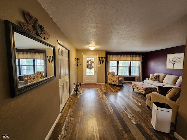 unfurnished living room with a wealth of natural light, dark wood-type flooring, and a textured ceiling