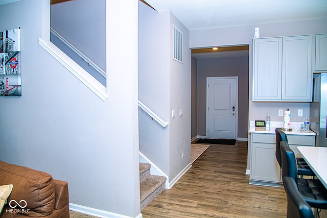 interior space with stainless steel fridge and dark hardwood / wood-style flooring