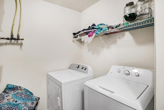 washroom with a textured ceiling and independent washer and dryer