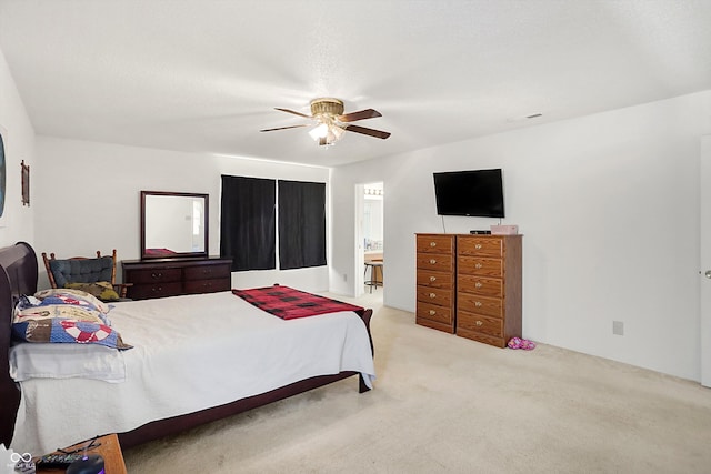 bedroom featuring light colored carpet, ceiling fan, and ensuite bathroom