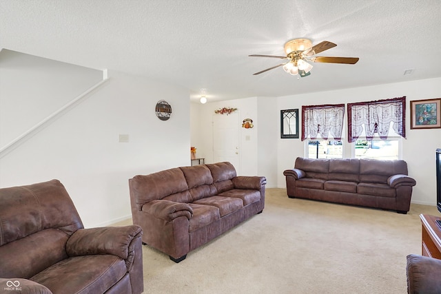 living room featuring a textured ceiling, light colored carpet, and ceiling fan