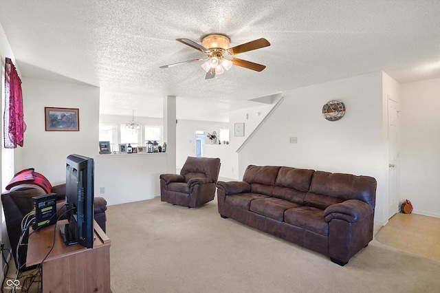 living room with ceiling fan with notable chandelier, light colored carpet, and a textured ceiling