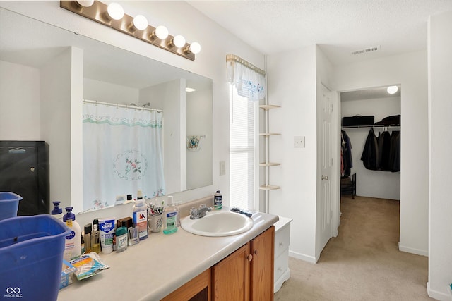 bathroom featuring vanity, a textured ceiling, and curtained shower