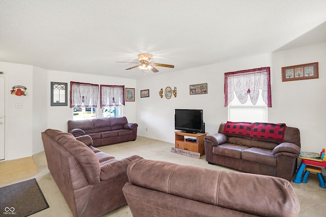 carpeted living room featuring ceiling fan and a textured ceiling