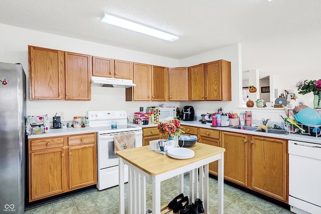 kitchen with white appliances, sink, and a textured ceiling