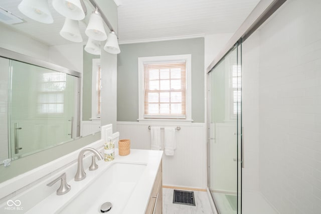 bathroom featuring vanity and a shower with door