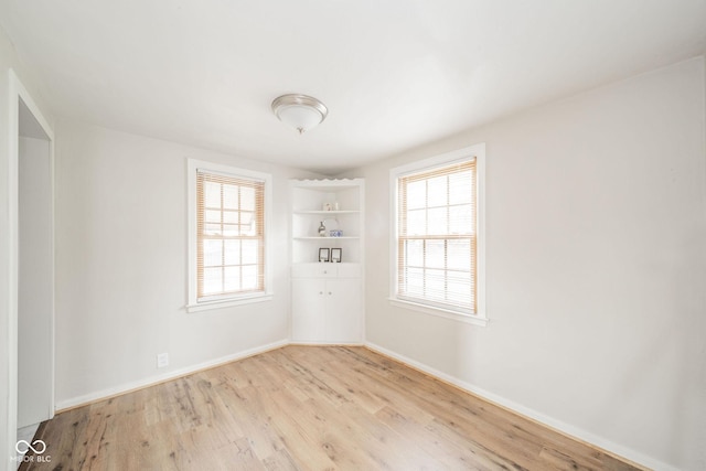 spare room featuring plenty of natural light and light hardwood / wood-style floors