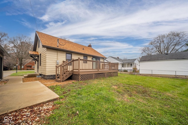 back of property featuring a wooden deck, a yard, and a patio