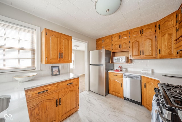 kitchen with appliances with stainless steel finishes and decorative backsplash