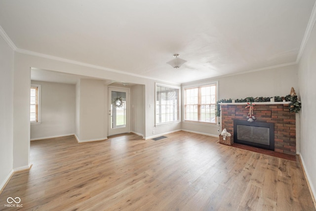 living room with crown molding, a fireplace, and light wood-type flooring