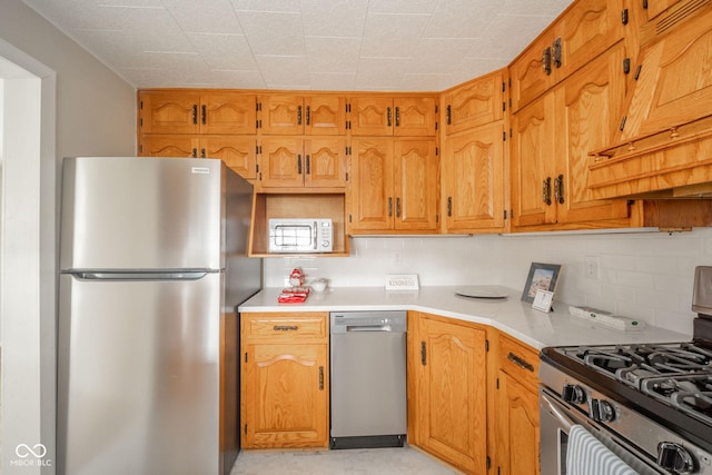 kitchen featuring stainless steel appliances and tasteful backsplash