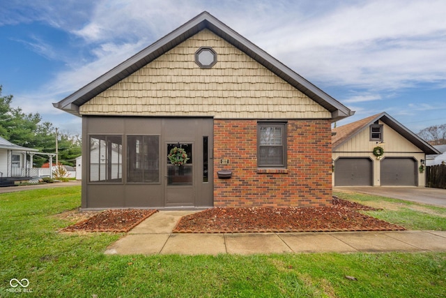 view of front of property featuring a garage, a sunroom, and a front lawn