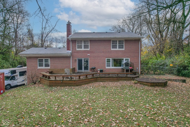 back of house with a wooden deck and a lawn