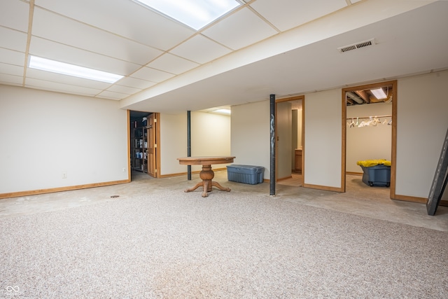 basement with a paneled ceiling and carpet floors