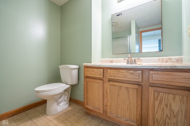 bathroom with vanity, a textured ceiling, and toilet