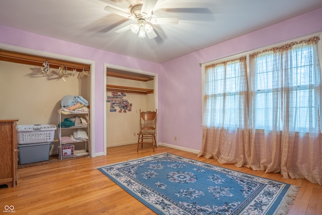 living area with wood-type flooring and ceiling fan