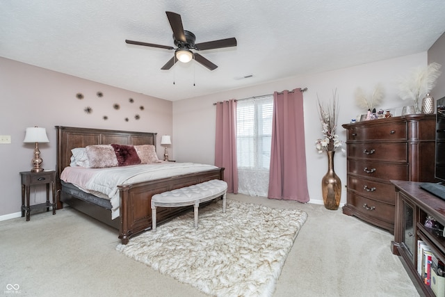 bedroom featuring ceiling fan, a textured ceiling, and light colored carpet