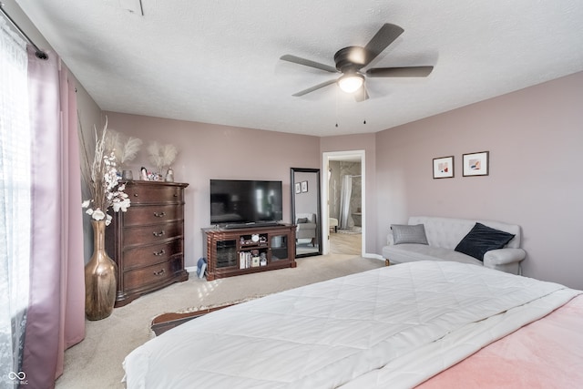 bedroom featuring ceiling fan, a textured ceiling, and light colored carpet