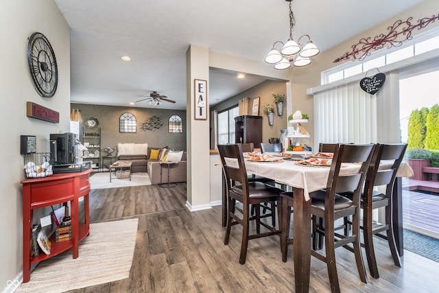 dining area featuring hardwood / wood-style floors and ceiling fan with notable chandelier