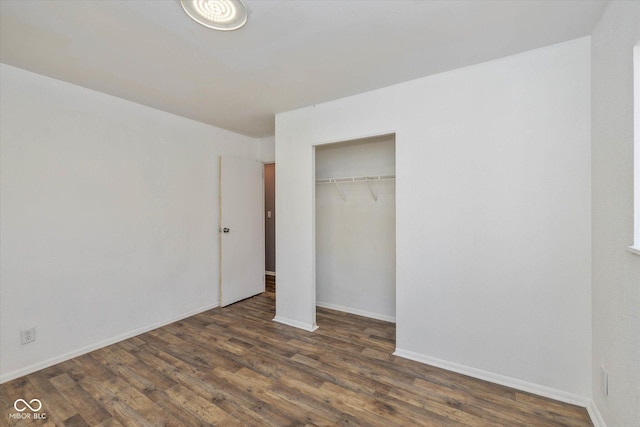 unfurnished bedroom featuring a closet and dark hardwood / wood-style flooring