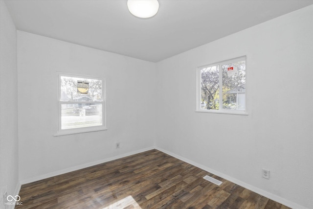 empty room with dark hardwood / wood-style flooring