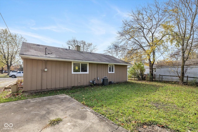 rear view of house with central AC unit, a yard, and a patio