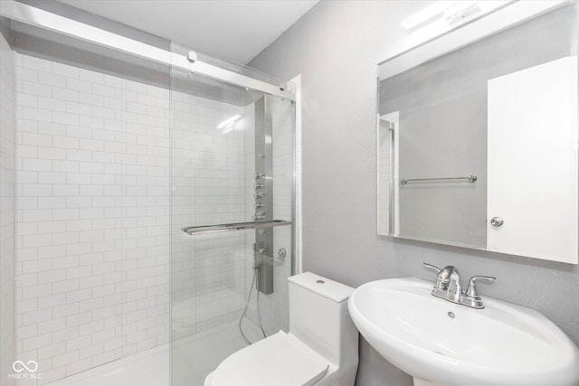 bathroom with sink, an enclosed shower, and toilet